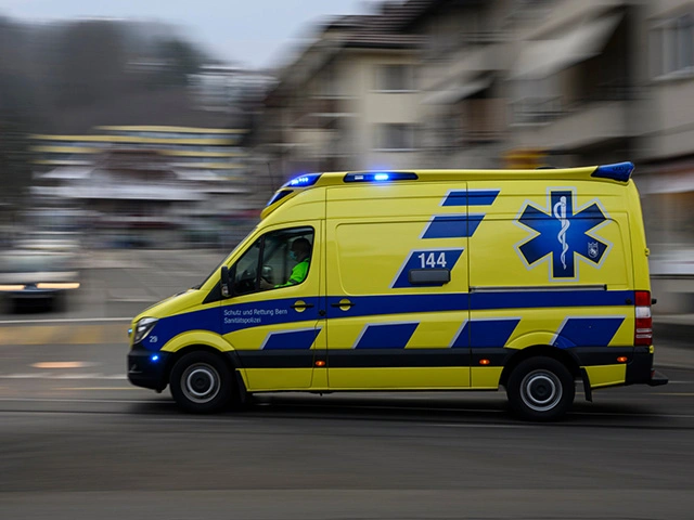Rettungswagen mit Blaulicht fährt durch Stadt im Einsatz, Notfallversorgung durch den Rettungsdienst in der Schweiz.
