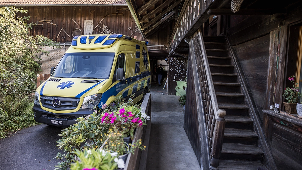 Rettungswagen des Rettungsdienstes steht vor einem traditionellen Bauernhaus im Einsatz, um medizinische Hilfe vor Ort zu leisten.